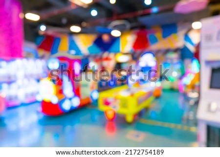 Blur image of arcade machine game for children game play in modern shopping mall,colorful neon lights.