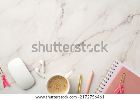 Business concept. Top view photo of workspace pink planners cup of coffee pens computer mouse clips and wireless earbuds on white marble background with copyspace