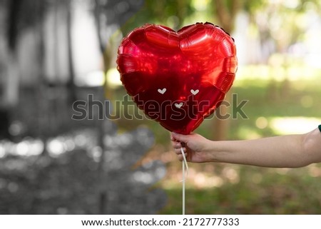 inflatable heart in red color on forest background. Holiday card, concept of happy valentines day love in the air.