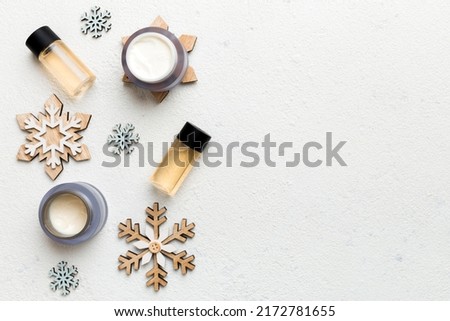 Makeup products and Christmas decorations on color background. Top view New year Beauty concept with copy space.