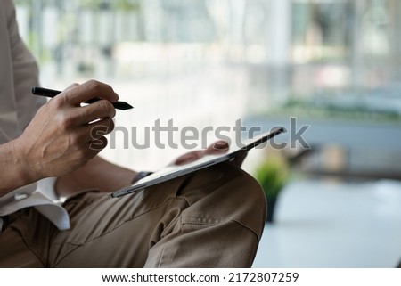 Close-up of businessman using blank screen digital tablet at desk while searching for business information in the modern workplace