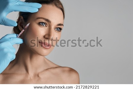 Beautiful woman during facial mesotherapy for smoothing of mimic wrinkles around eyes with beautician. Anti-aging injections for rejuvenation and lift skin Royalty-Free Stock Photo #2172829221