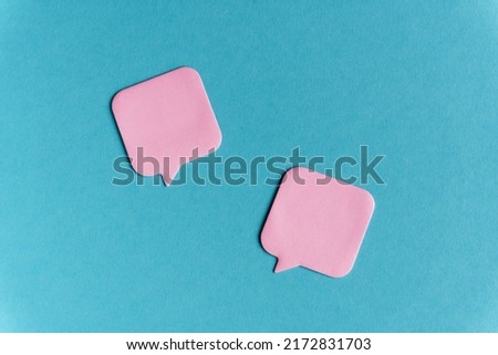 Two pink stickers on blue paper background. School, stationery mockup minimalistic concept. Empty paper notes template for your logo, message