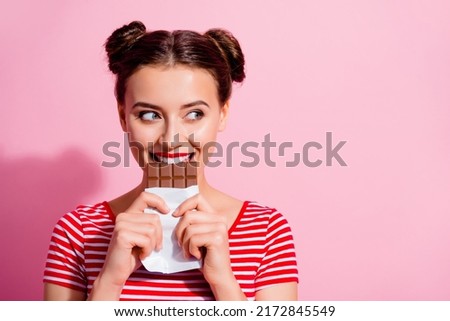 Picture of charming funny female break her diet plan eat yummy chocolate bar isolated on pink color background