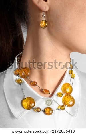 Amber jewelry set on the girl: necklace with amber stones and earrings. Fashion bijouterie. Royalty-Free Stock Photo #2172855413