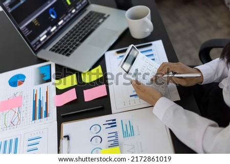 Business woman use a calculator to calculate income and expenses in order to manage budgets to pay off debt. Financial planning and investment analysis. Royalty-Free Stock Photo #2172861019