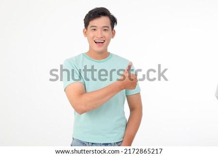 Happy handsome smiling young Asian man with hand gesture to show message on copy space, isolated on background