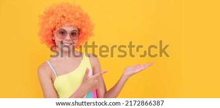 happy kid in sunglasses pointing finger on yellow background copy space, promotion. Funny teenager child on party, poster banner header with copy space.