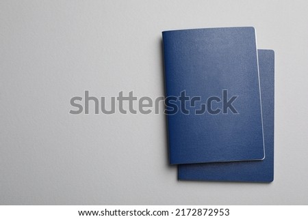 Blank blue passports on grey background, flat lay with space for text Royalty-Free Stock Photo #2172872953