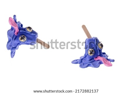 Creative concept with ice cream with eyes on a stick. Ice cream from light clay isolated on white background. Purple ice cream with eyes