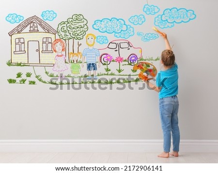 Cute child girl painting on light grey wall indoors