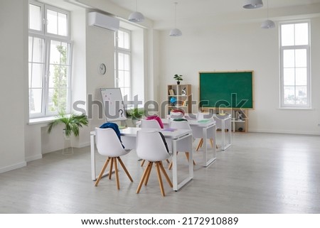Classroom school.Interior of clean spacious classroom ready for new school year. Empty room with white walls, comfortable desks, chairs, green blackboard, whiteboard. Back to school. Royalty-Free Stock Photo #2172910889