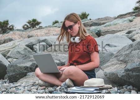 Remote work.Girl freelancer works remotely on the seashore.workation, remote work,WFVH,Van Life vibes work from vacation home,work travel,remotely work.Travelling Royalty-Free Stock Photo #2172912069
