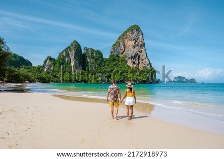 Railay Beach Krabi Thailand, the tropical beach of Railay Krabi, a couple of men and woman on the beach, Panoramic view of idyllic Railay Beach in Thailand with a traditional long boat.  Royalty-Free Stock Photo #2172918973