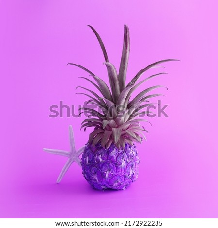abstract photo of purple pineapple over neon pink background. Holidays, beach and tropical theme