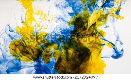 Blue and yellow ink in water. Abstract background.