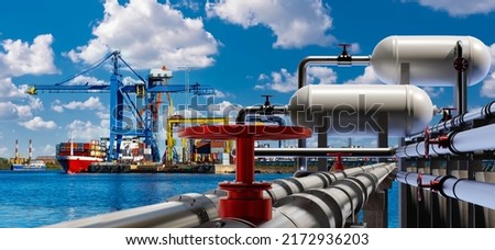Port terminal. Berth for unloading liquefied gas. Supply of liquefied gas across ocean. Terminal for loading gas onto ships. LNG equipment near sea. Port crane unloading ship in background.  Royalty-Free Stock Photo #2172936203