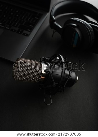 Studio microphone, studio headphones on a laptop on a gray background. Low angle view. Software, audio, podcast, blogging, journalism, radio, presentation.