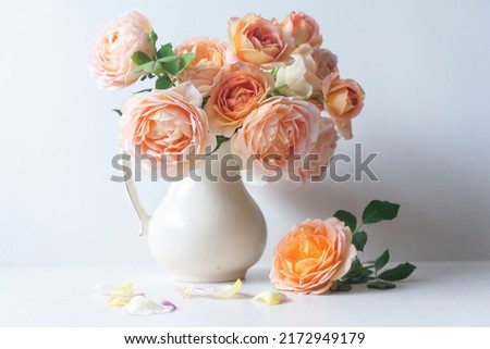 Beautiful orange peony roses on a light background.