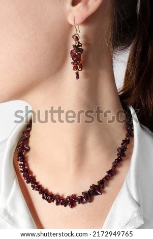 Luxurious vintage garnet jewelry set on the girl: necklace and earrings. Fashion antique jewelry. Royalty-Free Stock Photo #2172949765