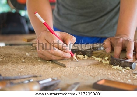 craftsman using the pencil marking make on the wooden product working at carpentry workshop  furniture project 