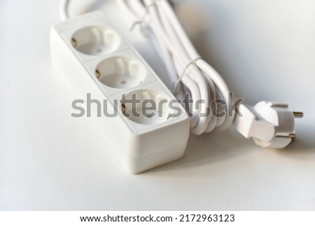 White electrical extension cord mains filter with sockets on a white background. Flat icon on white backdrop.