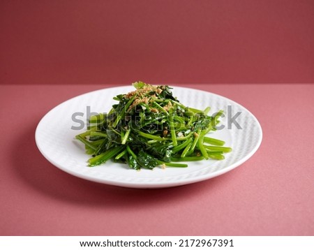 Stir-Fried Spinach with Garlic with chopsticks served in a dish isolated on mat side view on grey background Royalty-Free Stock Photo #2172967391