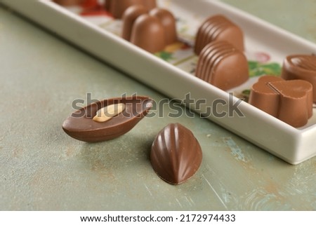 Chocolate with the shape of almond. Peanuts in the chocolate. Delicious almond shaped chocolate pictures. Chocolate in table in the background. 