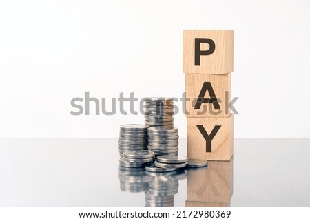 PAY word is made of wooden building blocks lying on the gray table, business concept