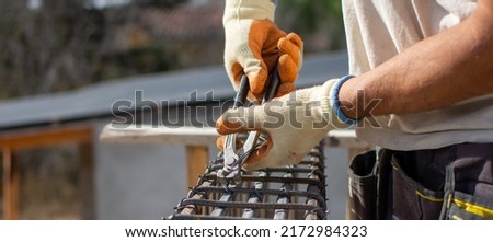 male builder performs work on the roof, fastens corrugated sheets