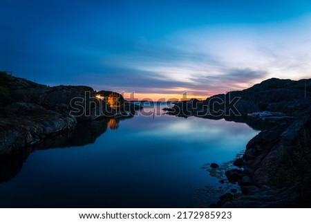 A beautiful summer evening in June by the sea outside Grundsund. Bohuslän, Sweden. In the foreground, the canal to Grundsund can be seen. In the background you see all the way to the horizon. Royalty-Free Stock Photo #2172985923