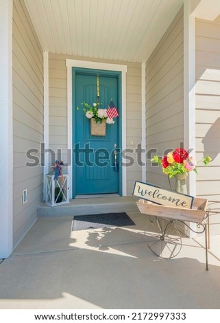Vertical Decorated entrance of a house with welcome sign on a wooden barrow