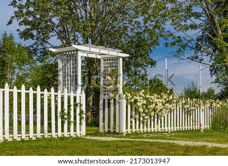 Garden gate with White Picket Fence and white roses. Romantic photo for wedding background. Nobody, selective focus