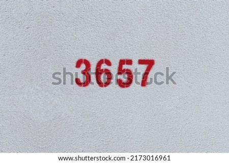 Red Number 3657 on the white wall. Spray paint.

