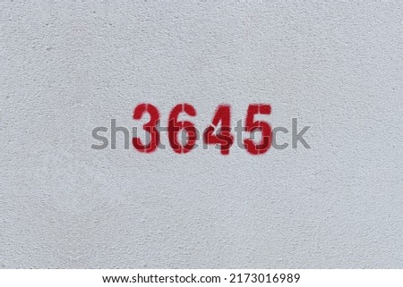 Red Number 3645 on the white wall. Spray paint.
