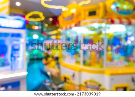 Blur image of arcade machine game for children game play in modern shopping mall,colorful neon lights.