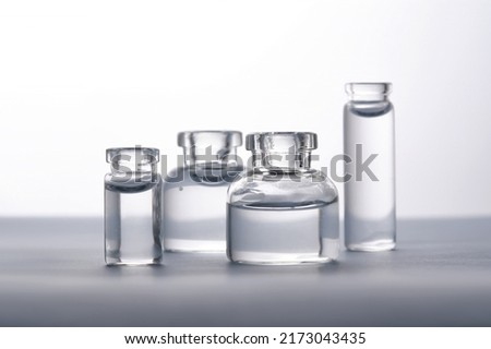 Different bottles of water on a light background. It can fit the theme of cosmetics, glass and freshness. Royalty-Free Stock Photo #2173043435