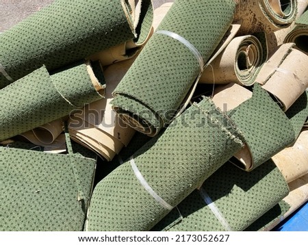 Cut up and rolled old green carpet are ready hauling services Royalty-Free Stock Photo #2173052627