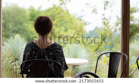 Woman resting at a cafe on a green road