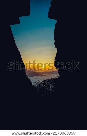 The sunrise and the sea of ​​mist in the morning, looking through the rock crevices. Royalty-Free Stock Photo #2173063959