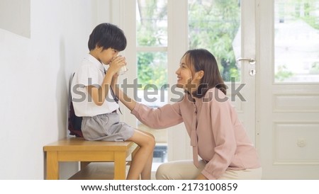 Portrait of happy smiling Asian Family drinking milk. A student prepaing to go to school at home or house  in family relationship. Love of mother, and son. People lifestyle. Royalty-Free Stock Photo #2173100859