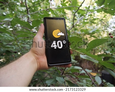 Thermometer marking 40 degrees celsius High Temperature show on Mobile Screen in hot summer. Climate change leads to more extreme weather event in Europe. Red heat warnings in Hungary. Green concept.