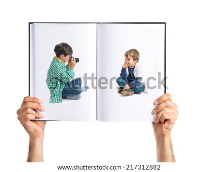 Boy sitting and photographing his friend printed on book