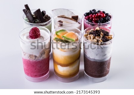 Vanilla ice cream in two glasses with melon jam and melon pieces on a light background. Vertical orientation