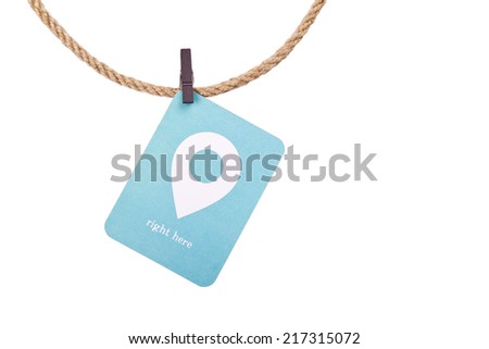 Blue note with the words "right here" and sign of location point attached to a rope with a clothespin