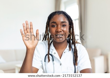 African oman doctor talking online with patient, making video call, looking at camera, young female wearing white uniform with stethoscope speaking, consulting and therapy concept