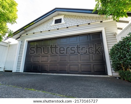 Garage with wooden roller door painted black. Copy space stock photo.