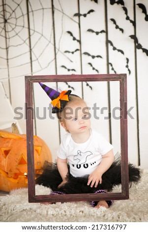 Girl with Down syndrome sitting near a big orange pumpkin