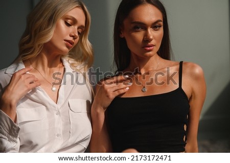 Two elegant, beautiful, young girls with jewelry around their necks. Portrait Royalty-Free Stock Photo #2173172471