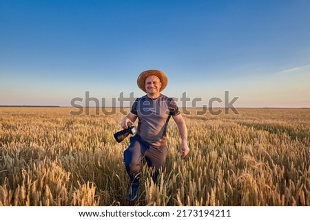 Photographer with camera shooting landscapes in a ripe wheat field